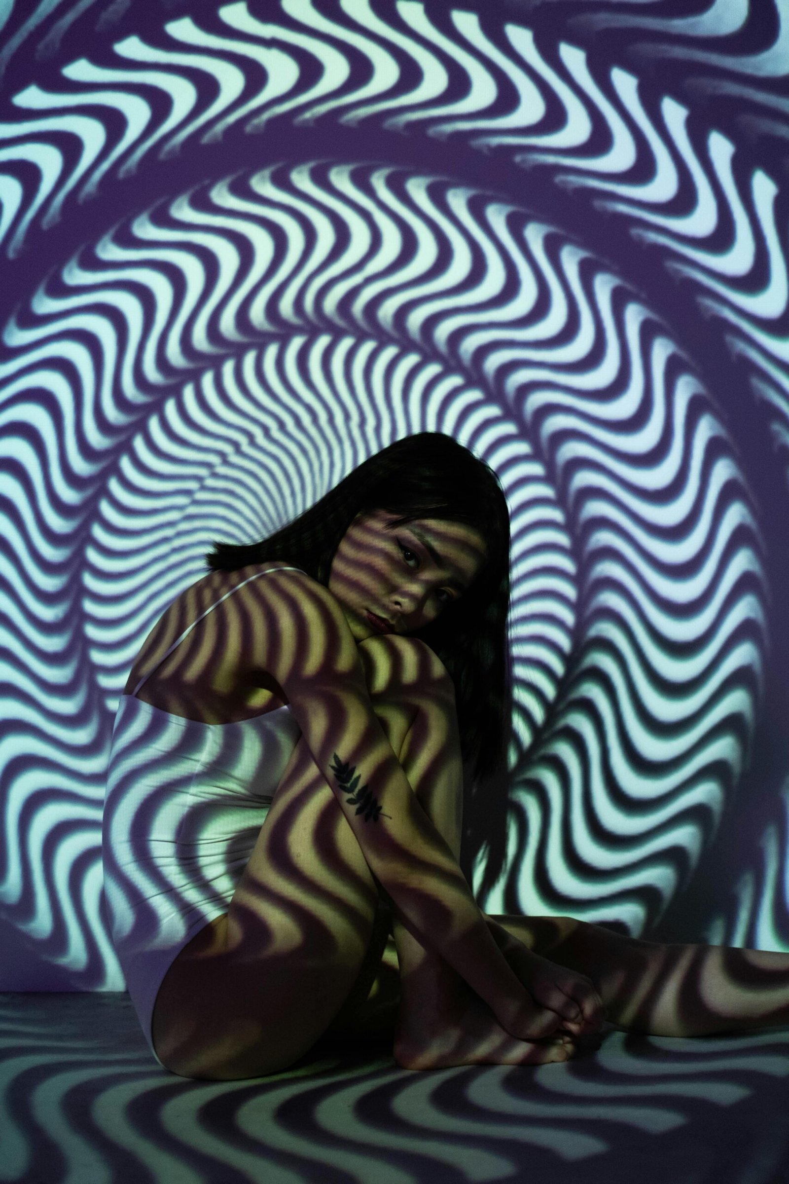 A woman in a distorted tunnel pattern, creating a psychedelic and optical illusion effect.